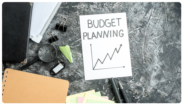 Note card reading Budget Planning next to an upward trending chart